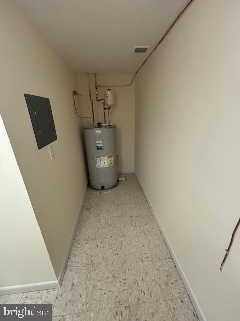 utility room featuring electric panel and electric water heater