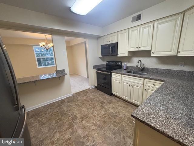 kitchen featuring sink, a chandelier, hanging light fixtures, dark stone countertops, and black appliances