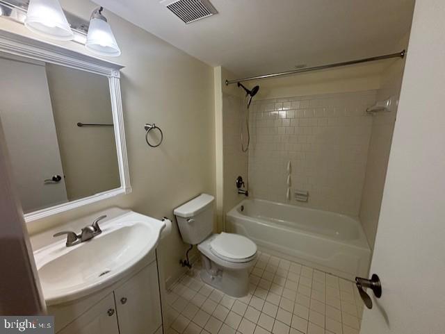 full bathroom with vanity, tiled shower / bath, tile patterned floors, and toilet