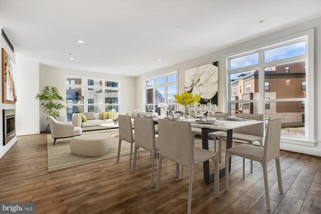 3234 Royal Fern Pl, Rockville, MD 20852 - dining space featuring a glass covered fireplace, recessed lighting, and hardwood / wood-style flooring