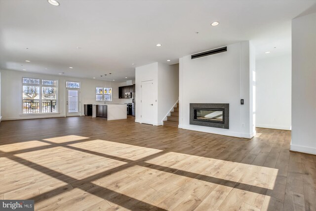 3234 Royal Fern Pl, Rockville, MD 20852 - unfurnished living room featuring recessed lighting, a glass covered fireplace, baseboards, and wood finished floors