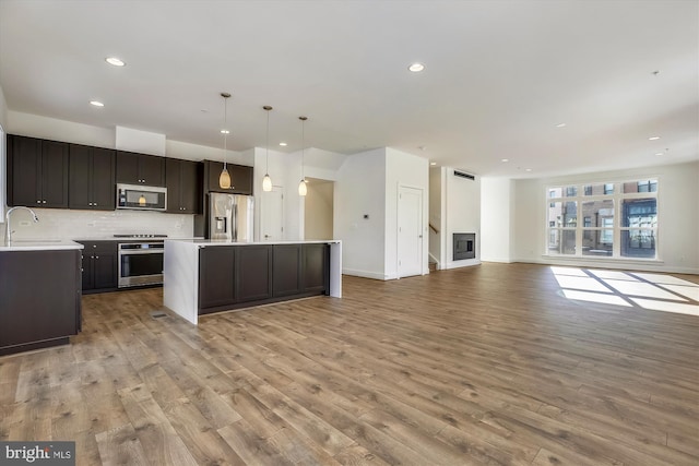 3234 Royal Fern Pl, Rockville, MD 20852 - kitchen featuring a sink, appliances with stainless steel finishes, a center island, open floor plan, and light wood-style flooring