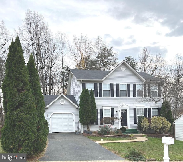 colonial house with a front yard and a garage