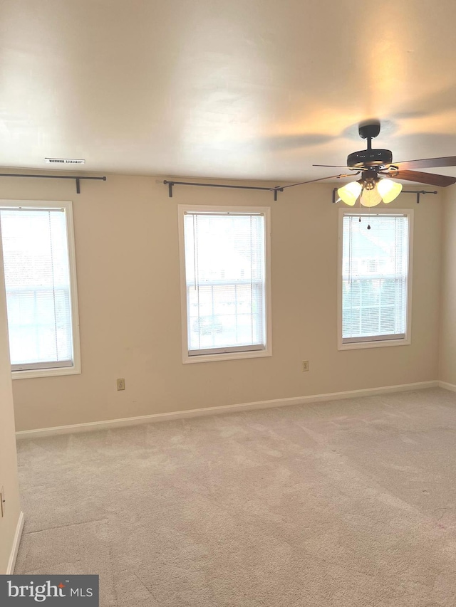 spare room with ceiling fan and light carpet