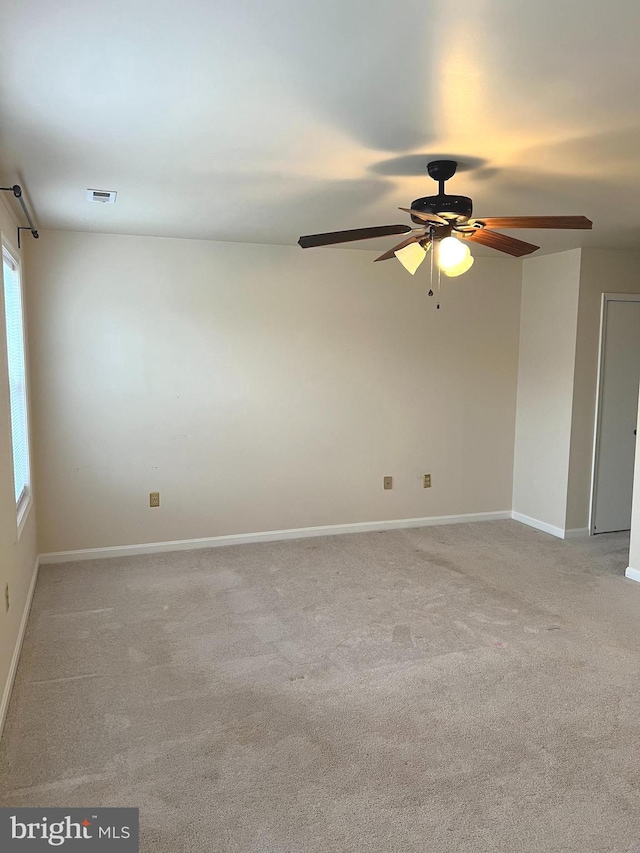 carpeted spare room featuring ceiling fan