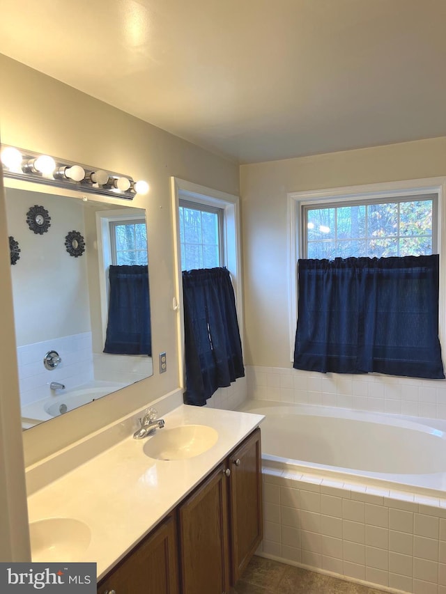 bathroom featuring tiled bath and vanity