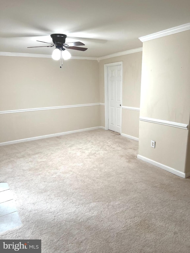 unfurnished room with ceiling fan, light colored carpet, and crown molding