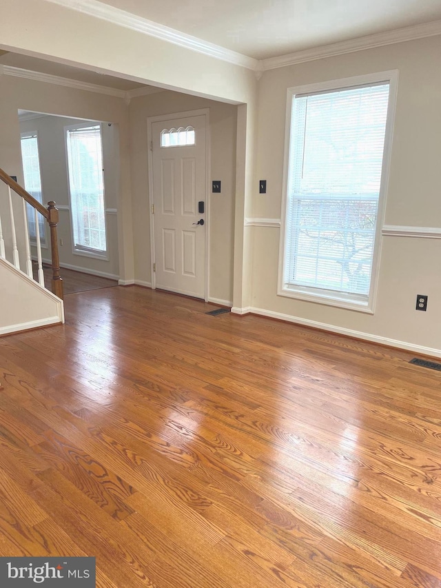 entryway with hardwood / wood-style flooring, plenty of natural light, and crown molding