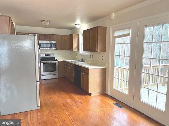 kitchen featuring light wood-type flooring, stainless steel appliances, and sink