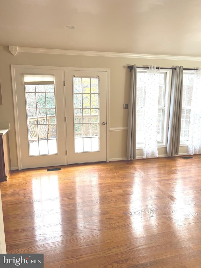 doorway to outside with ornamental molding and a healthy amount of sunlight