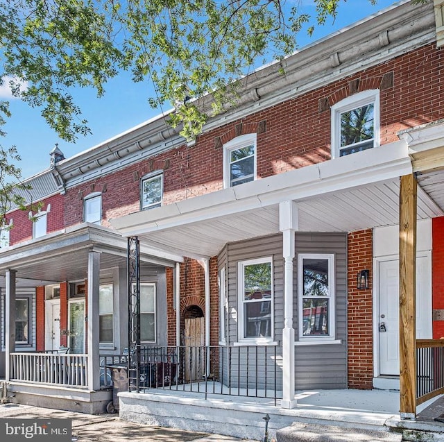 townhome / multi-family property featuring covered porch