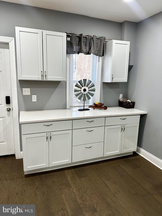 kitchen featuring dark wood-type flooring and white cabinetry