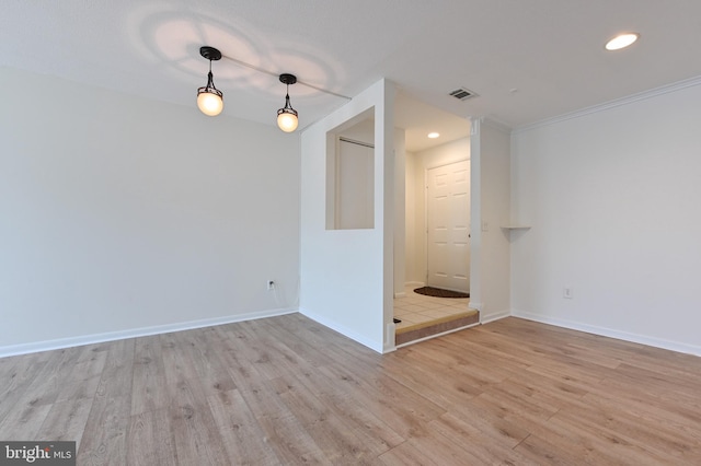 spare room featuring visible vents, light wood-style flooring, recessed lighting, crown molding, and baseboards