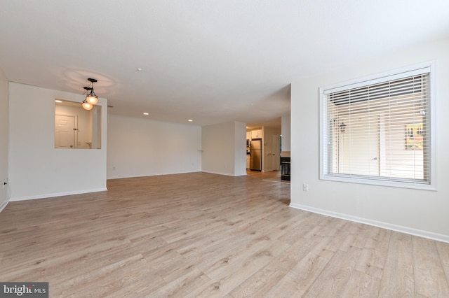 unfurnished living room with light wood-style floors and baseboards