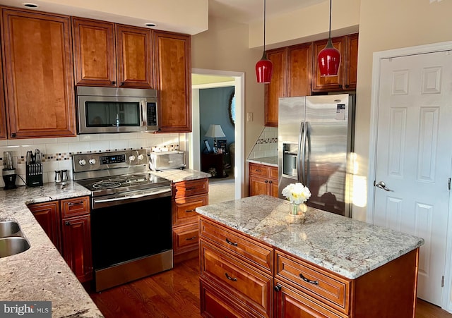 kitchen featuring decorative light fixtures, decorative backsplash, appliances with stainless steel finishes, and light stone counters