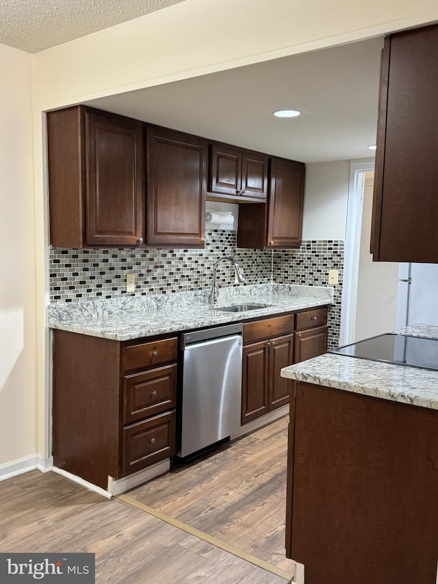 kitchen with tasteful backsplash, wood-type flooring, dishwasher, sink, and dark brown cabinets