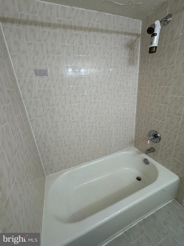 bathroom featuring tile patterned floors and tiled shower / bath