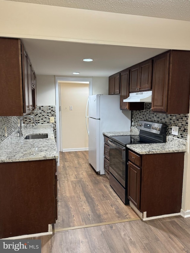 kitchen featuring light stone countertops, dark hardwood / wood-style flooring, tasteful backsplash, sink, and electric range