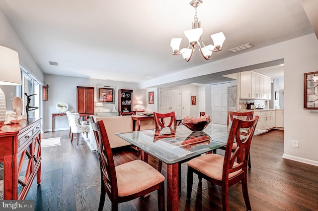 dining room with dark hardwood / wood-style flooring and a chandelier