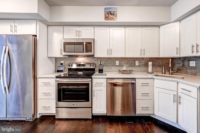 kitchen with tasteful backsplash, sink, stainless steel appliances, and white cabinetry