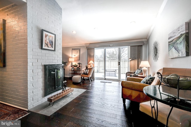 living room featuring crown molding, a fireplace, and hardwood / wood-style floors