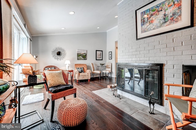 living room with a fireplace, crown molding, and dark hardwood / wood-style floors