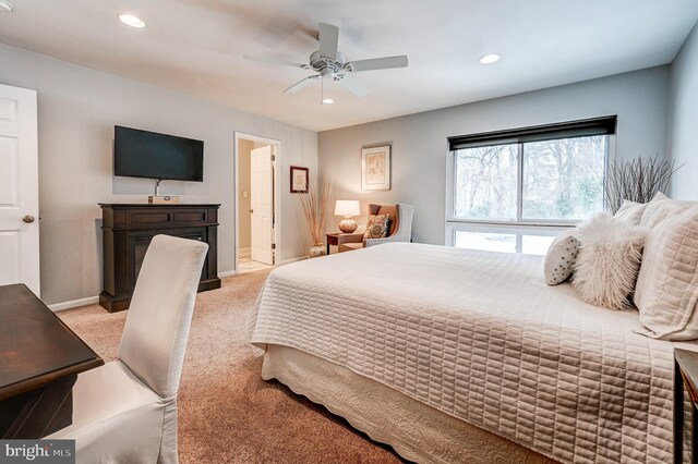 bedroom featuring ceiling fan, light carpet, and connected bathroom