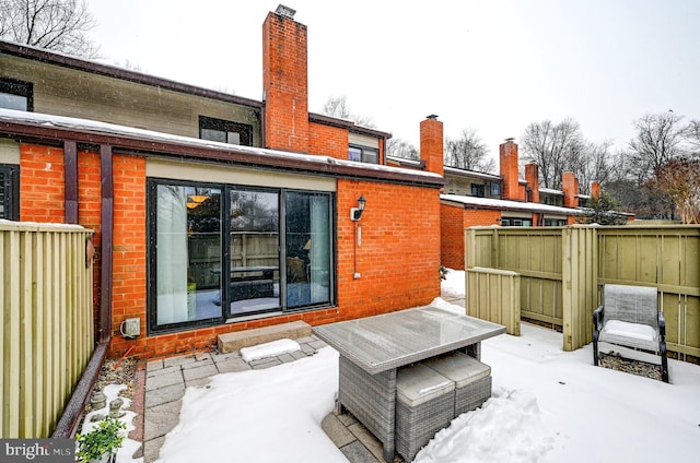 view of snow covered rear of property