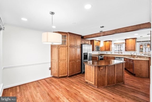 kitchen featuring a center island, pendant lighting, sink, dark wood-type flooring, and stainless steel appliances