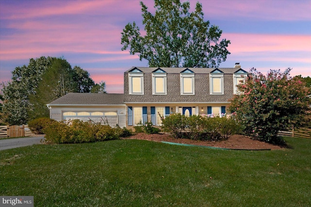 cape cod-style house with a garage and a lawn