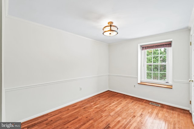 empty room featuring light hardwood / wood-style floors and ornamental molding