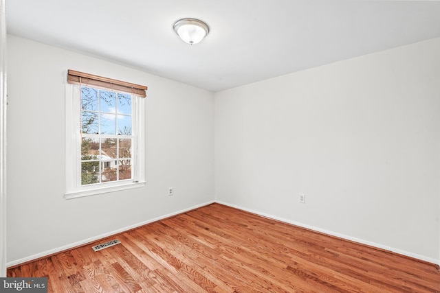 unfurnished room with hardwood / wood-style flooring