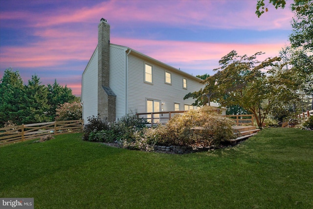 back house at dusk featuring a yard