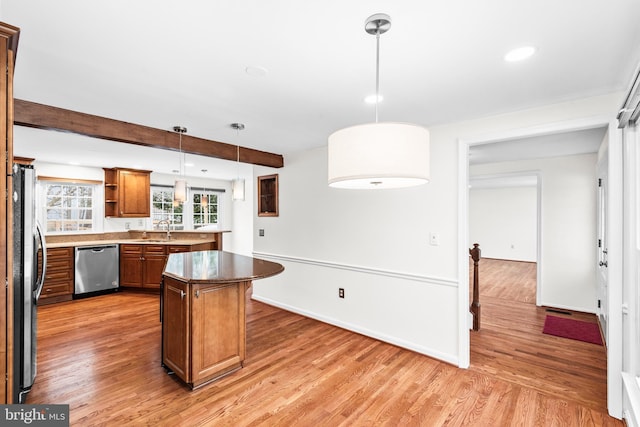 kitchen featuring hardwood / wood-style flooring, sink, pendant lighting, and stainless steel appliances