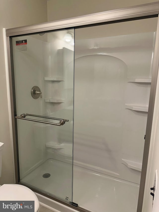 bathroom featuring a shower with shower door