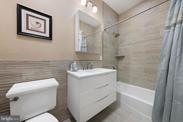 full bathroom featuring vanity, toilet, tile walls, and shower / bath combo with shower curtain