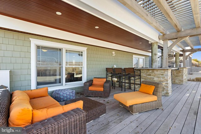 wooden terrace with an outdoor living space and exterior bar