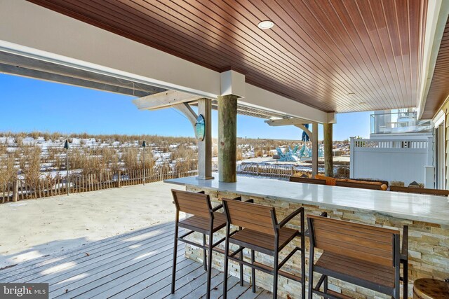 snow covered deck featuring exterior bar