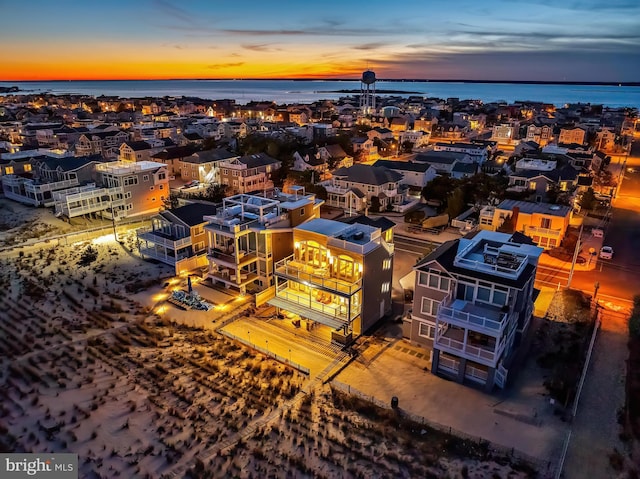 aerial view at dusk featuring a water view