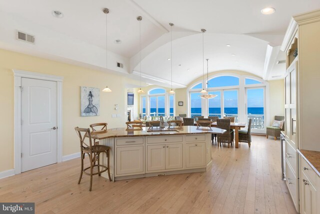 kitchen featuring a center island, hanging light fixtures, sink, and a water view