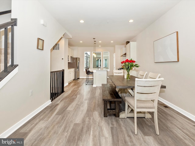 dining room with light wood-type flooring and sink