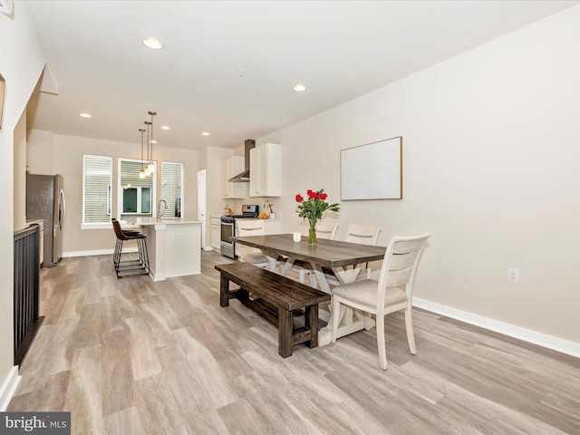 dining space with sink and light hardwood / wood-style flooring