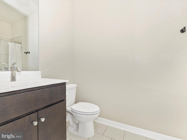 bathroom with toilet, vanity, and tile patterned floors