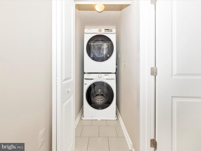 laundry area with light tile patterned floors and stacked washer / dryer