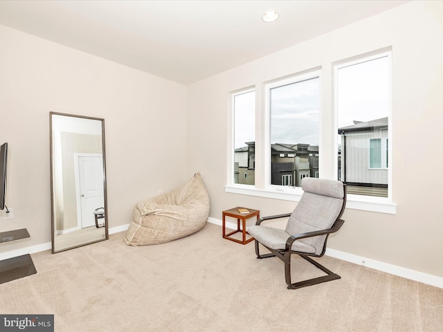 sitting room featuring light colored carpet