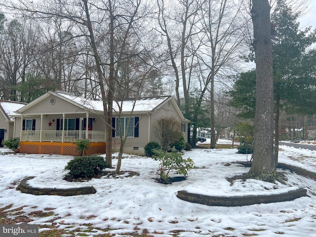 snow covered property with covered porch