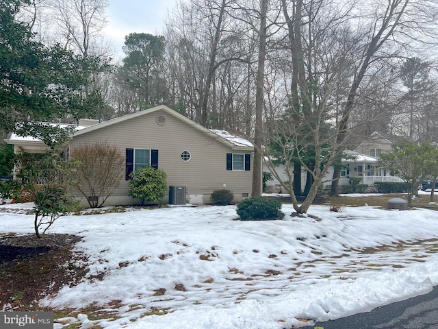 snow covered property with central air condition unit