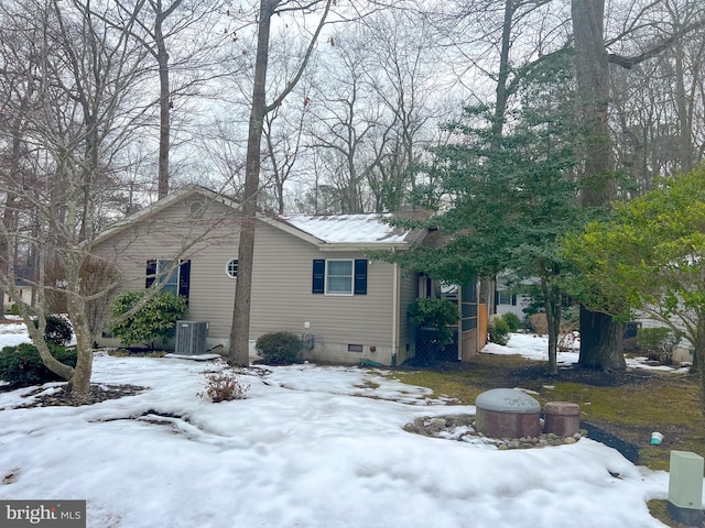 snow covered property featuring central air condition unit