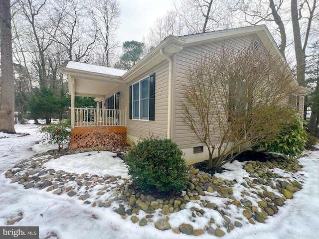 snow covered property featuring covered porch