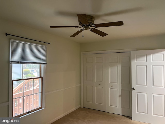 unfurnished bedroom featuring light carpet, ceiling fan, and a closet